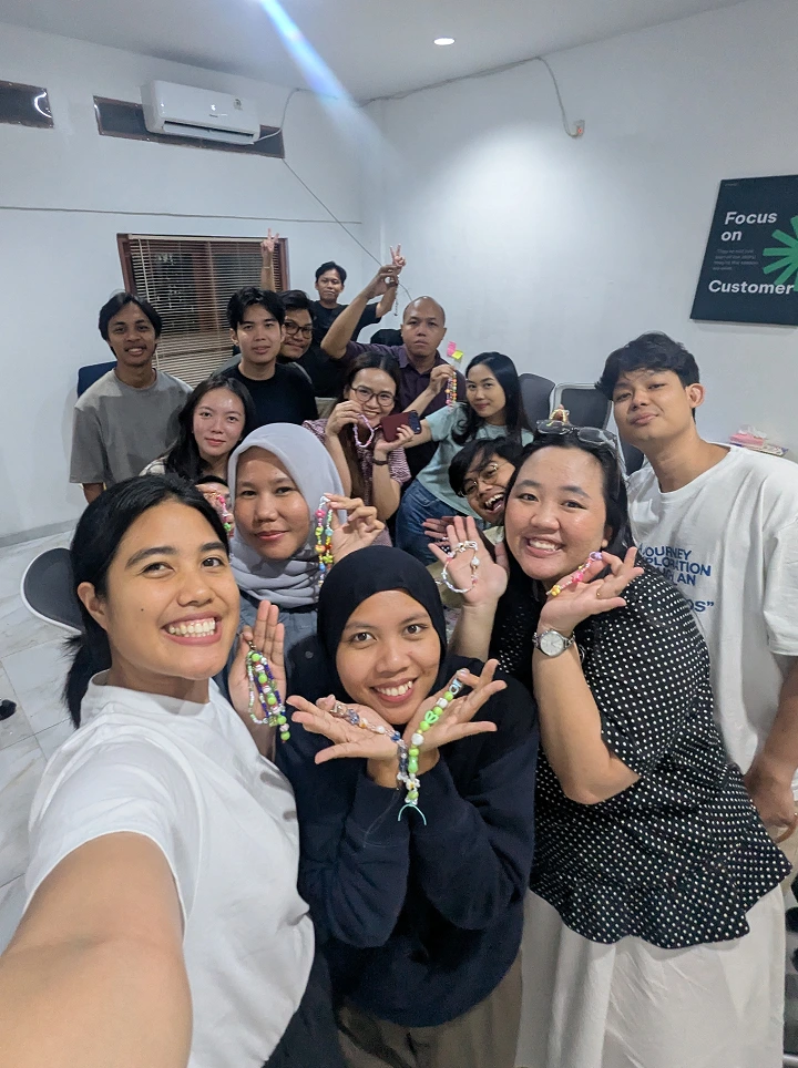 Group of smiling young people taking a selfie indoors.